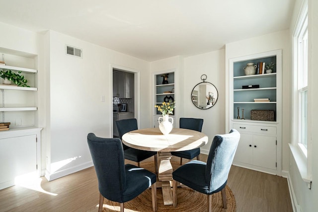 dining room featuring hardwood / wood-style floors and built in features