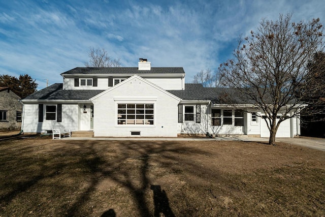 rear view of property featuring a garage and a lawn