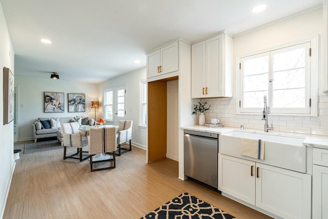 kitchen featuring white cabinetry, dishwasher, sink, decorative backsplash, and light hardwood / wood-style floors