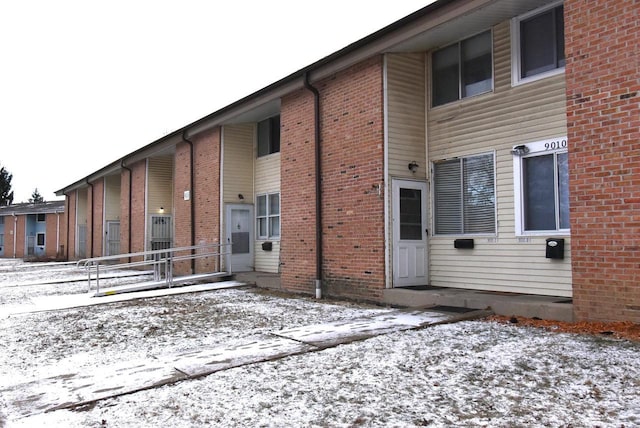 view of snow covered rear of property