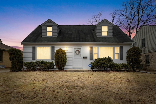 new england style home featuring a lawn