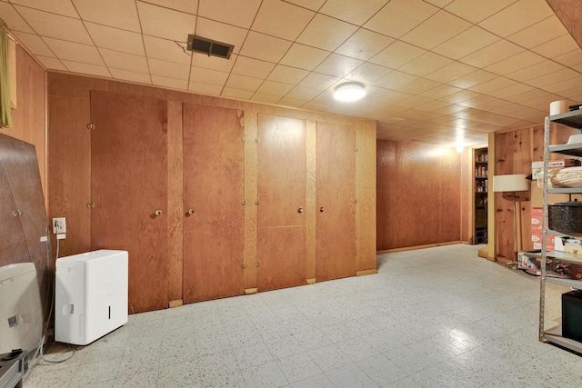 basement featuring wood walls