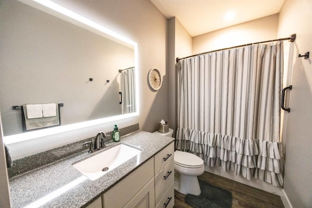 bathroom with curtained shower, vanity, and toilet