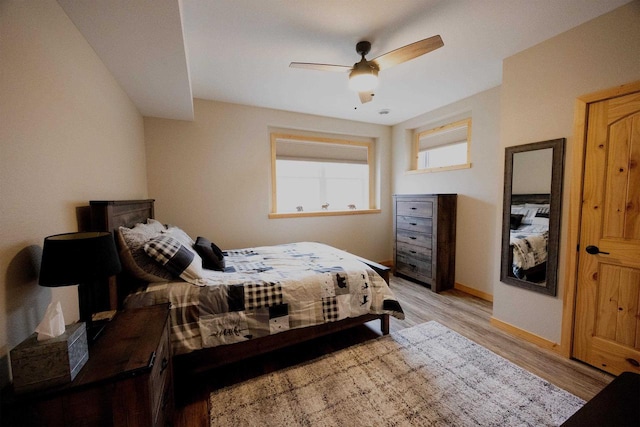 bedroom featuring a ceiling fan, light wood-type flooring, and baseboards