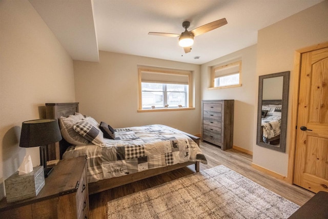 bedroom featuring light wood-style flooring, baseboards, and ceiling fan