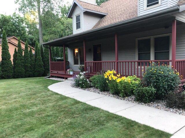 doorway to property with a porch and a yard