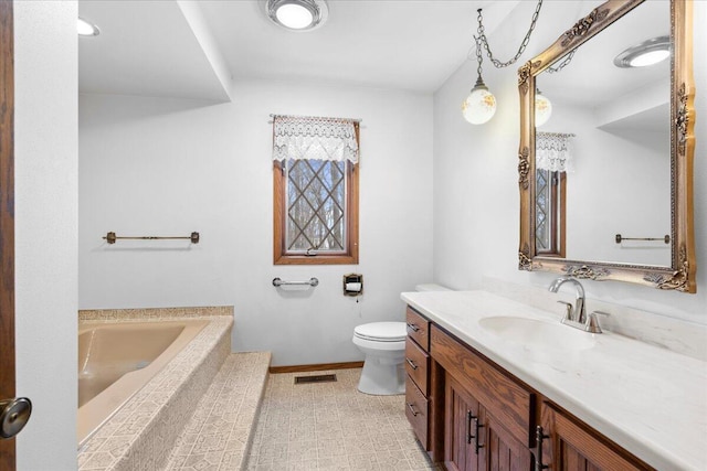 bathroom featuring toilet, a bath, and vanity