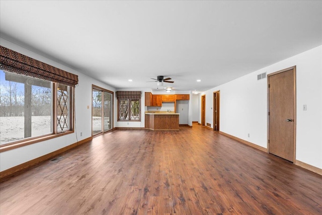 unfurnished living room with ceiling fan and dark wood-type flooring