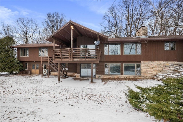 snow covered rear of property featuring a wooden deck