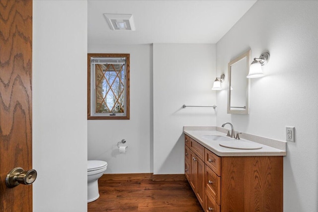 bathroom with toilet, vanity, and hardwood / wood-style flooring