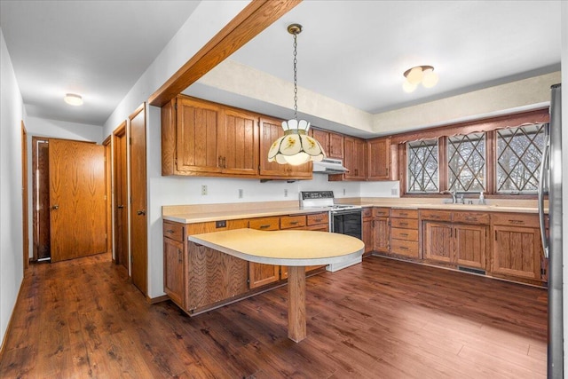 kitchen featuring range with electric stovetop, stainless steel fridge, decorative light fixtures, dark hardwood / wood-style flooring, and sink