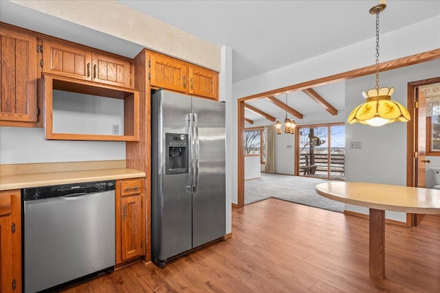 kitchen featuring appliances with stainless steel finishes, decorative light fixtures, beamed ceiling, an inviting chandelier, and light wood-type flooring