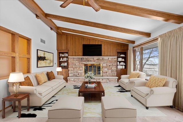 carpeted living room featuring vaulted ceiling with beams, wooden walls, a fireplace, built in features, and ceiling fan