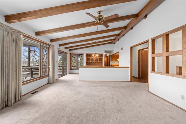 unfurnished living room with ceiling fan with notable chandelier, light colored carpet, and vaulted ceiling with beams