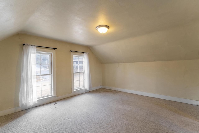 additional living space with light colored carpet and lofted ceiling