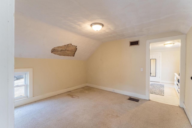 bonus room featuring lofted ceiling and light carpet