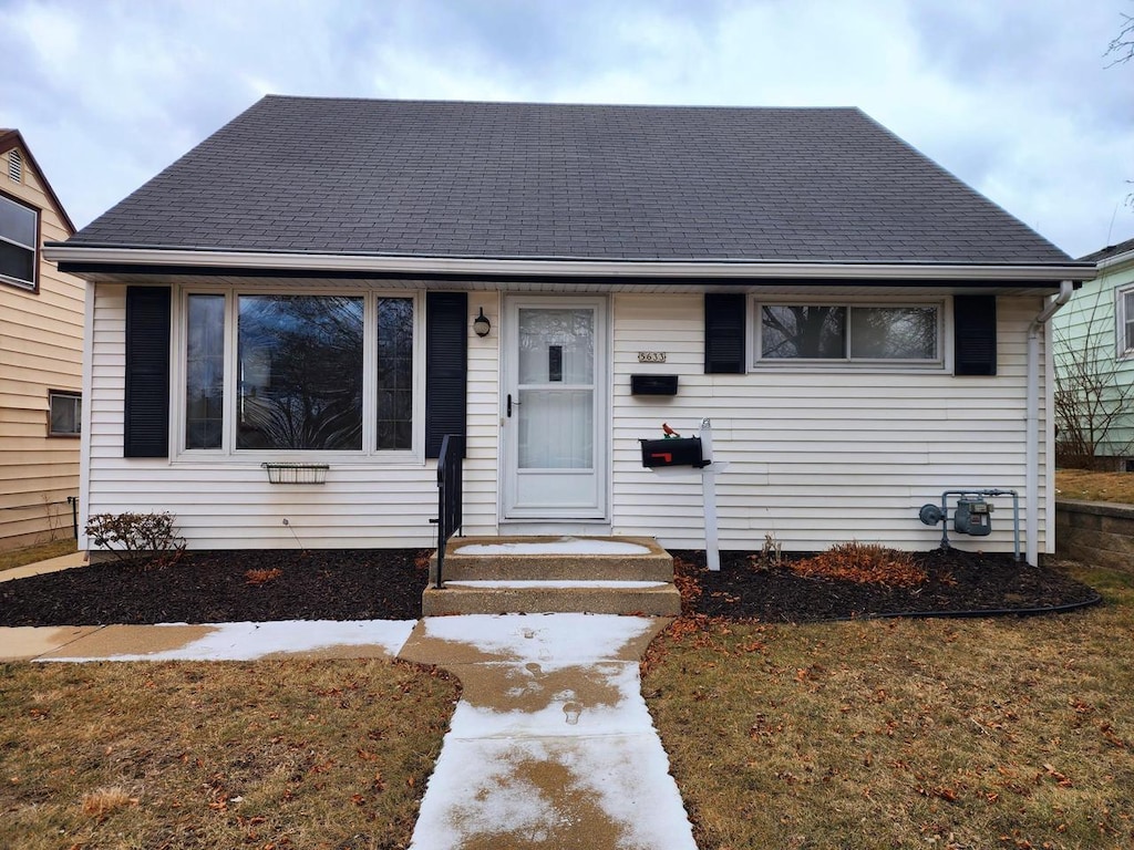 bungalow-style house featuring a front lawn