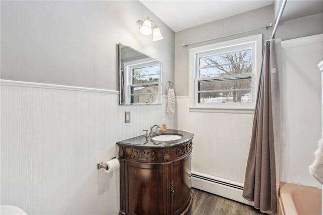 bathroom with baseboard heating, wood-type flooring, vanity, and shower / tub combo with curtain