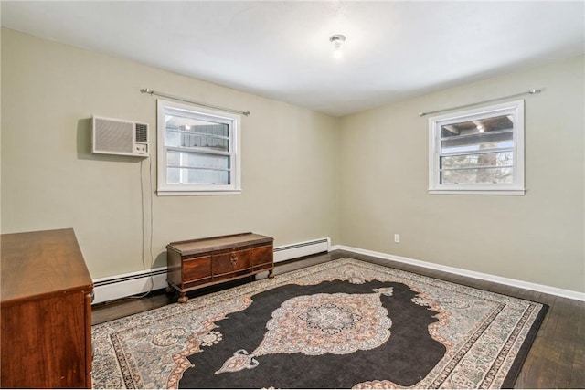 spare room featuring wood-type flooring, a wall mounted AC, a wealth of natural light, and a baseboard radiator