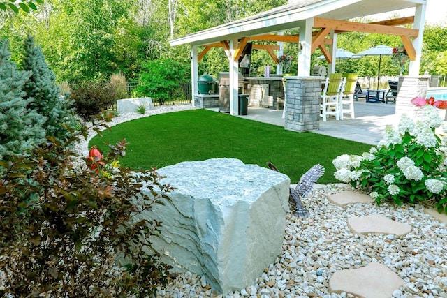 view of yard featuring area for grilling, an outdoor bar, and a patio