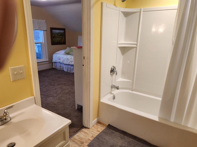 bathroom with vanity, vaulted ceiling, and shower / tub combo