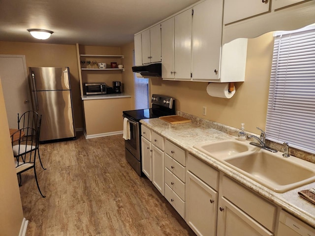 kitchen featuring stainless steel appliances, sink, white cabinets, and light hardwood / wood-style floors