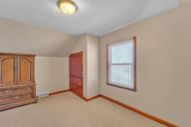 interior space featuring light carpet and vaulted ceiling