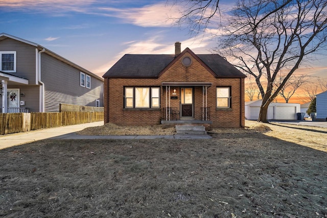 view of front of house featuring a garage, an outbuilding, and a yard