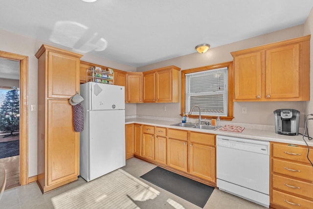 kitchen with sink, light brown cabinets, and white appliances