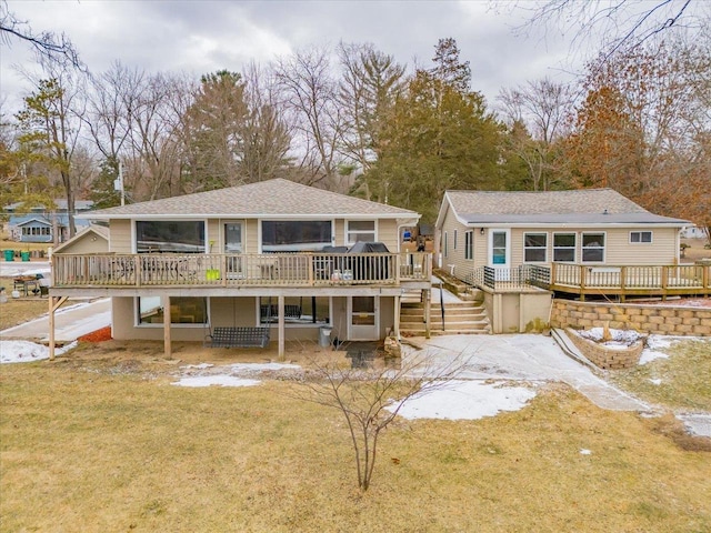 rear view of property with a deck and a yard