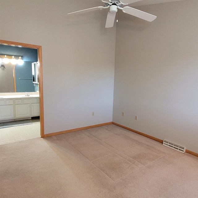 carpeted empty room featuring ceiling fan and sink