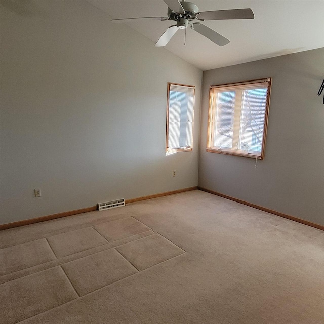 empty room featuring ceiling fan, carpet floors, and lofted ceiling