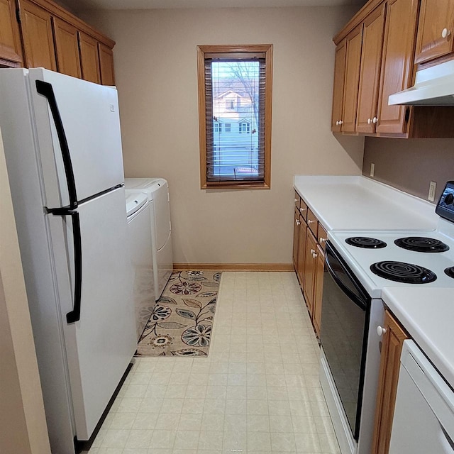 kitchen featuring white appliances and washing machine and dryer