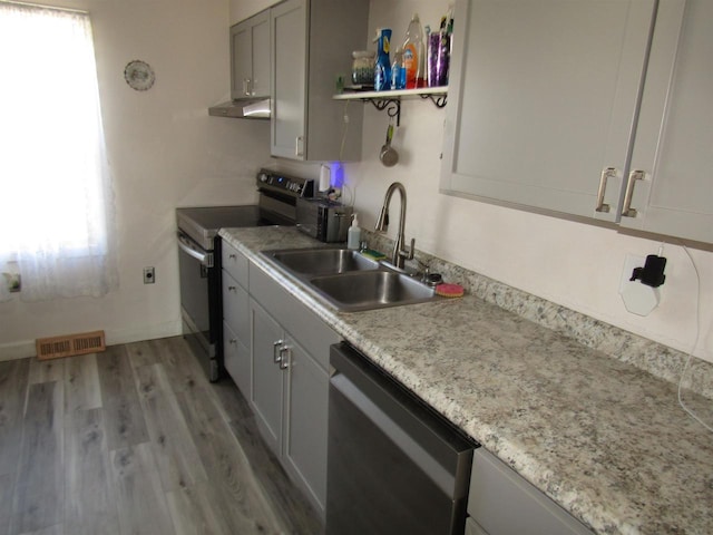 kitchen featuring light wood-type flooring, appliances with stainless steel finishes, and sink