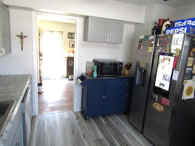 kitchen featuring stainless steel refrigerator with ice dispenser and light hardwood / wood-style flooring