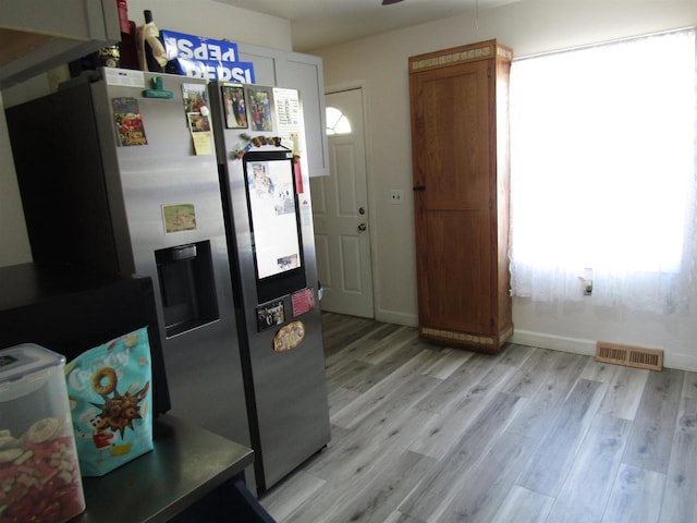 kitchen featuring ceiling fan, stainless steel fridge, white cabinetry, and light hardwood / wood-style flooring