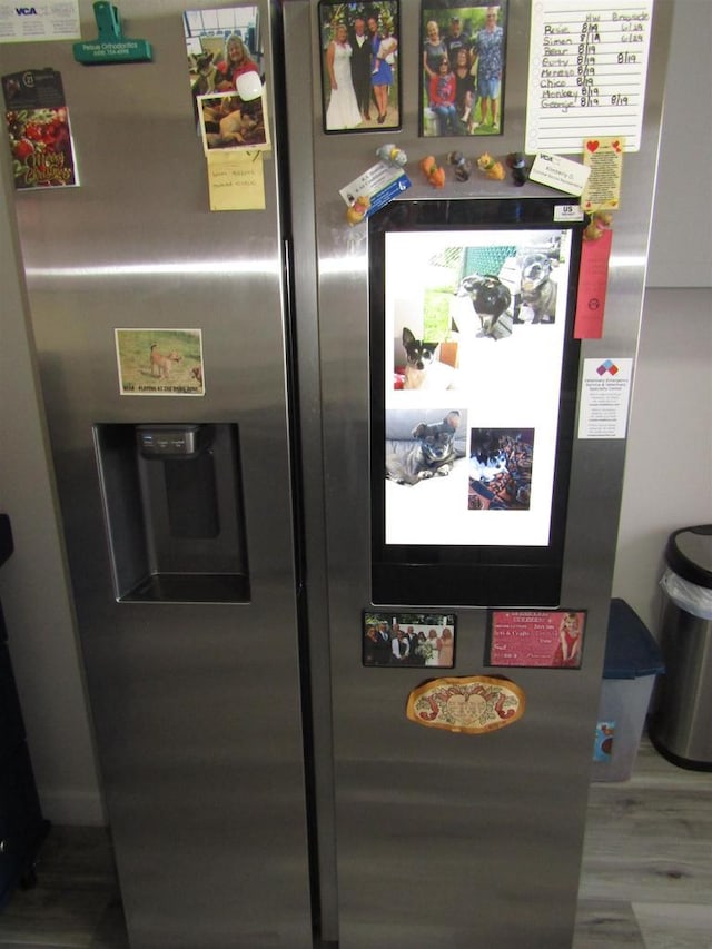 interior details with stainless steel fridge with ice dispenser and hardwood / wood-style flooring