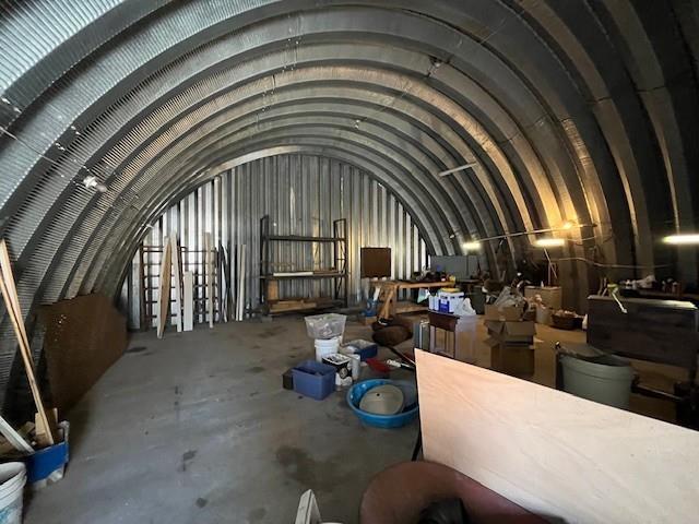 miscellaneous room featuring vaulted ceiling and concrete floors