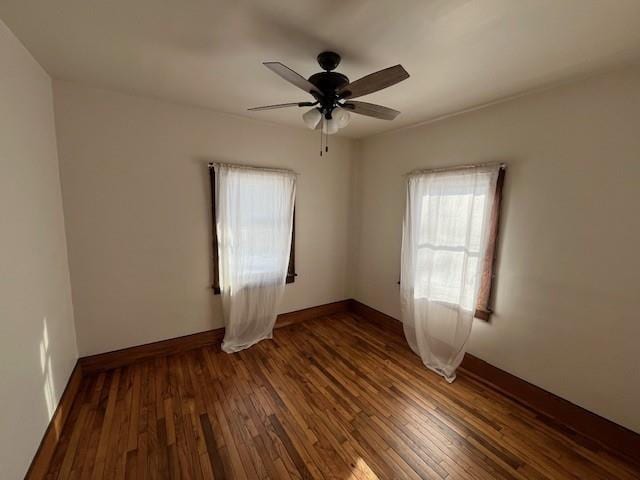 unfurnished room with ceiling fan and dark wood-type flooring