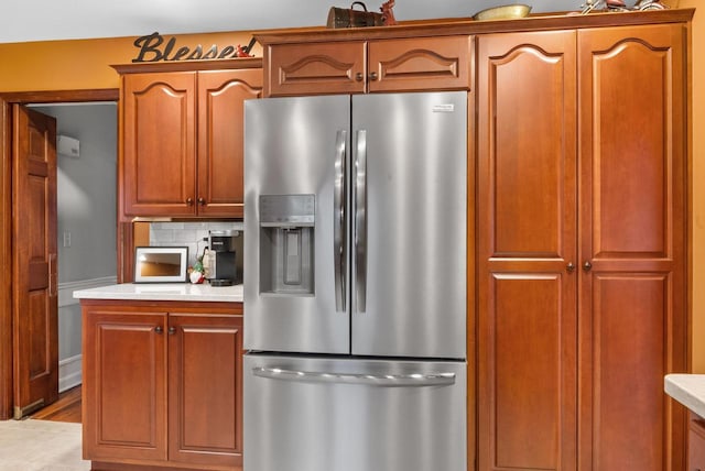 kitchen with stainless steel fridge and tasteful backsplash