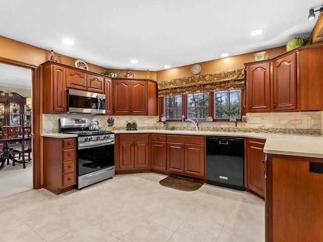 kitchen with backsplash, appliances with stainless steel finishes, and sink