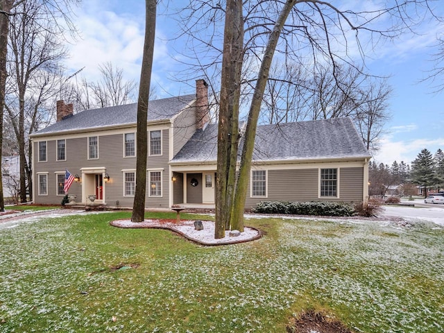 colonial-style house featuring a front yard