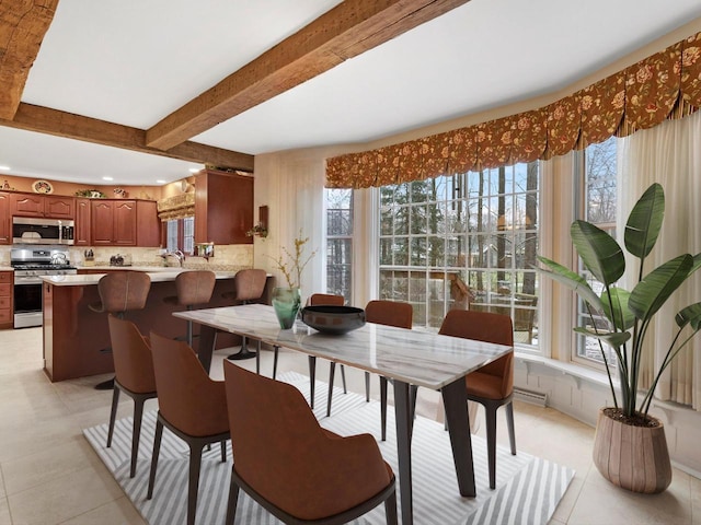 tiled dining room featuring beam ceiling and sink