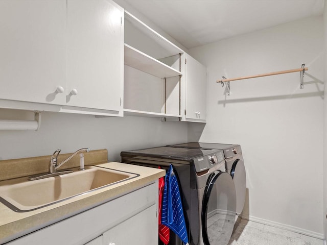 washroom featuring washing machine and dryer, sink, and cabinets