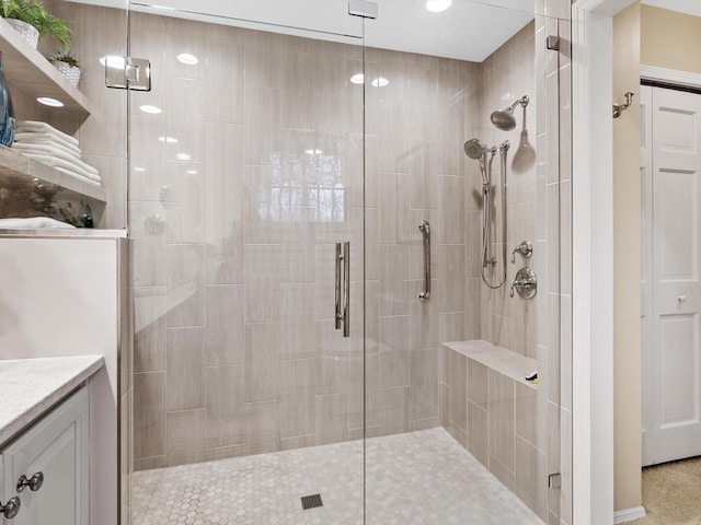 bathroom featuring vanity and a shower with door