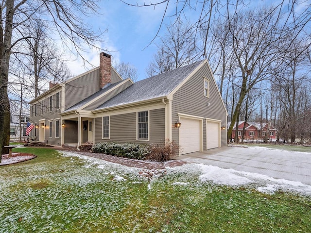 view of snowy exterior featuring a garage and a lawn