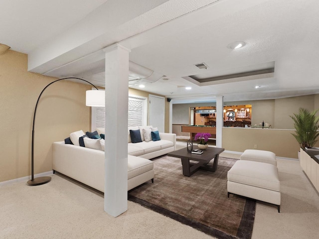 carpeted living room with a tray ceiling