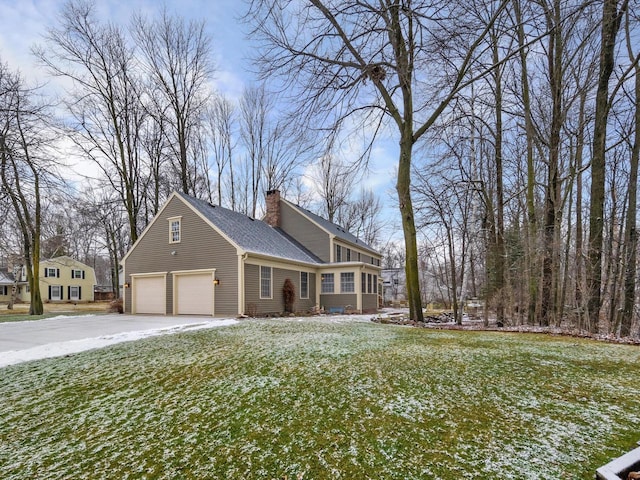 view of side of property featuring a garage and a lawn