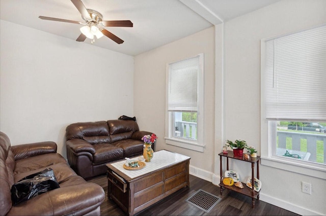 living room featuring dark wood-type flooring and ceiling fan