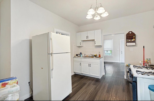 kitchen with a notable chandelier, white appliances, dark hardwood / wood-style flooring, white cabinets, and sink